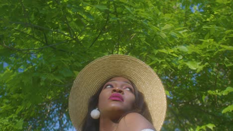 Beautiful-African-lady-enjoys-sunny-weather-in-park,-looks-around-smiling,-slomo