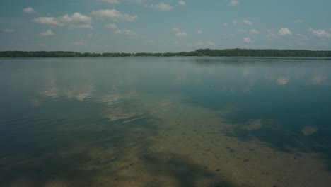 Wellen-Auf-Seichten-Gewässern-Des-Litauischen-Sees-Mit-Reflexion-Des-Blauen-Himmels