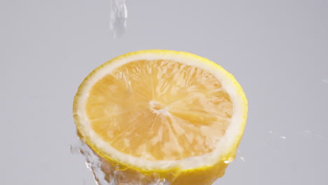 Makroaufnahme-In-Zeitlupe-Von-Fließendem-Wasser-Aus-Zitronenscheibe-Auf-Weißem-Hintergrund
