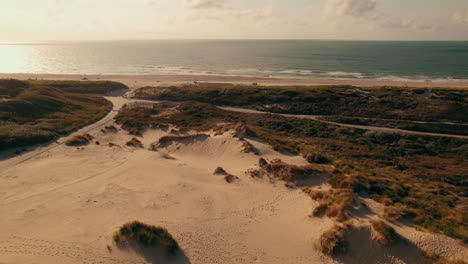Aerial-view-approaching-Kijkduin-Beach-at-sunset,-The-Hague