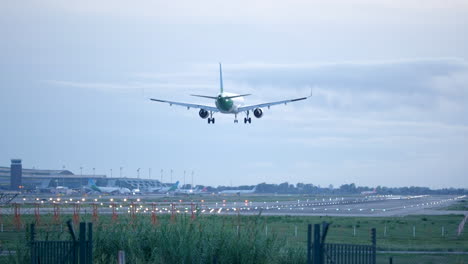 Slow-motion-shot-of-airplane-approaching-landing-lane,-overcast-cloudy-day