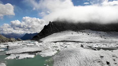 Sobrevuelo-Aéreo-Sobre-Los-Icebergs-En-El-Lago-Glaciar-Derretido-En-Partes-Remotas-De-Los-Alpes-Suizos-En-Un-Día-Soleado