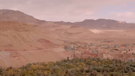Sandfarbene-Gebäude-In-Wüstenoasentönen-Fügen-Sich-Harmonisch-In-Den-Felsigen-Berghintergrund-Der-Region-Ouarzazate-Ein