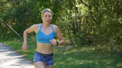 Blonde-Female-Athlete-Running-Fast-Through-Park,-4K-Slow-Motion