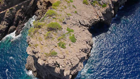 Revealing-drone-shot-of-a-rough-cliff-bay-with-yacht´s-anchor-and-mountain´s-in-the-backround