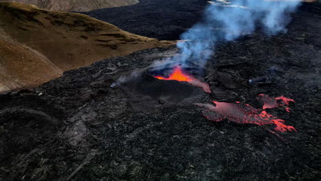 Panning-out-aerial-shot-of-the-hot-lava,-magma-and-ashes-coming-out-of-mouth-of-the-crater-in-Fagradalsfjall,-Iceland