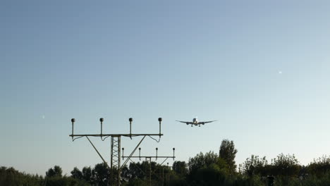 Gimbal-shot-of-airplane-approaching-airport-on-sunny-day,-preparing-to-land