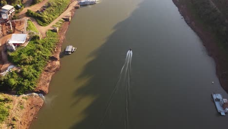 Eine-Dynamische-Kamerafahrt-Eines-Sich-Schnell-Bewegenden-Schnellboots,-Das-Durch-Den-Fluss-Iguazu-Kreuzt,-Grenze-Zwischen-Argentinien-Und-Brasilien