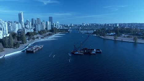 Vancouver-False-Creek-Fall-2022-drone-aerial-180-degree-flyover-4k-Granville-Island-sea-wall-sunny-hot-day-work-take-apart-cargo-ship-barge1-3