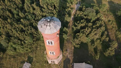Fast-aerial-drone-flight-towards-and-over-lost-place-lighthouse-with-zoom-in-at-the-coast-of-baltic-sea---Estonia-in-Europe---nature-helicopter-flyover-establishing-shot-summer-2022---bird-view