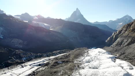 Aerial-flyover-over-the-Gorner-glacier-at-Gornergrat-in-Zermatt,-Switzerland-with-a-view-of-the-Matterhorn-in-the-background-of-the-icy-crevasses