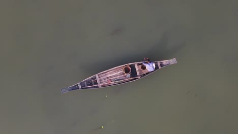 Small-traditional-Asian-boat-with-fisherman-in-Bangladesh,-aerial-overhead
