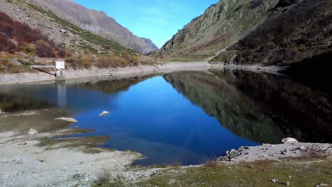 Tranquilas-Aguas-Azules-Del-Lago-Della-Rovina-Con-Fondo-De-Montañas,-Italia