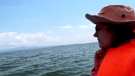 Close-up-of-a-woman-wearing-an-orange-lifejacket-on-a-guided-tour-across-Lake-Naivasha