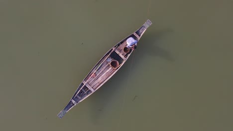 Majestic-overhead-view-of-lonely-fisherman-on-board-of-typical-Asian-boat