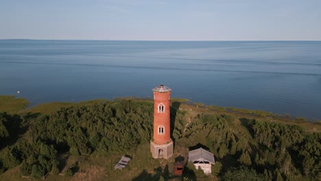 Static-aerial-drone-flight-over-old-lost-place-lighthouse-at-the-coast-of-baltic-sea---country-side-of-Estonia-in-Europe---nature-helicopter-flyover-establishing-shot-summer-2022---bird-view