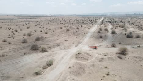 a-truck-drives-through-the-dusty-sand-roads-of-the-african-landscape