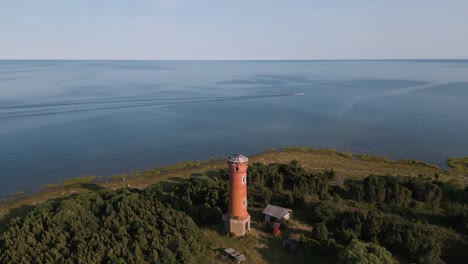 aerial-drone-flight-towards-a-lost-place-old-lighthouse-at-the-coast-of-baltic-sea---country-side-of-Estonia-in-Europe---nature-helicopter-flyover-establishing-shot-summer-2022---bird-view---ship