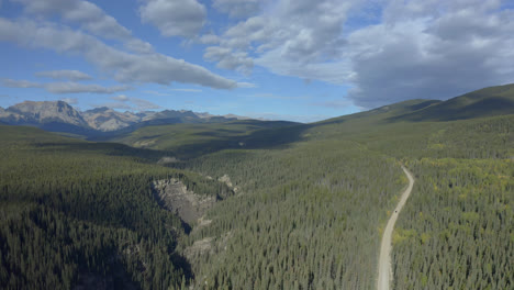 Vista-Panorámica-Del-Bosque-De-Coníferas-Con-Camino-Rural-Y-Montañas-Rocosas-Cerca-De-Nordegg,-Alberta,-Canadá