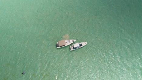 Zenitansicht-Zwei-Boote,-Die-Im-Flachen-Türkisfarbenen-Meerwasser-Festgemacht-Sind,-Warten-Auf-Männer-Beim-Kitesurfen,-Salinas-Los-Roques