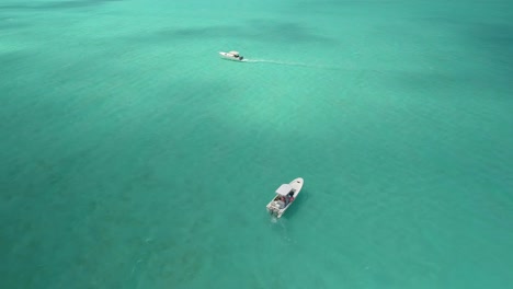Aerial-Top-view-two-motor-boats-stand-in-the-middle-of-caribbean-sea-turquoise-water,-Los-Roques