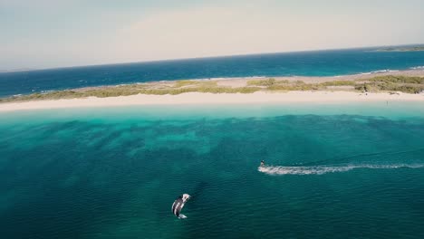 Aerial-view-Kite-surfing-front-of-salinas-island-on-blue-caribbean-sea,-Los-Roques