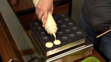 Adding-dough-to-a-hotcake-pancake-maker