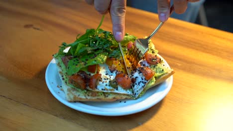 Avocado-toast-eating-in-slow-motion-cutting-and-dripping-yolk