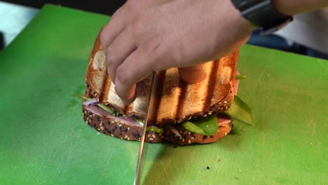 Koch-Schneidet-Halbes-Sandwich-Und-Zeigt-Zutaten