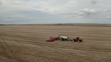 Tractor-drawn-Planter-Sowing-Seeds-On-Vast-Farmland-In-Saskatchewan,-Canada