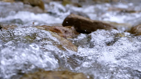 Clear-stream-running-through-stone-boulders-Abundant-river-flowing-in-slow-motion