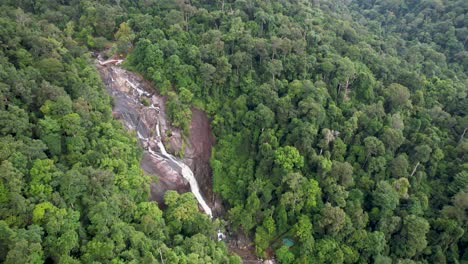 Beautiful-waterfall-in-Malaysian-forest,-drone-flyover,-Drone-following-stream