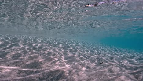 Authentic-fpv-underwater-scene-of-crystalline-turquoise-tropical-sea-water-with-rippled-surface-and-reflections-on-seafloor-with-blue-background