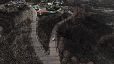 Vehicle-Entering-Small-Town-Wildfire-Area-In-El-Pont-de-Vilomara,-Spain---aerial-drone-shot