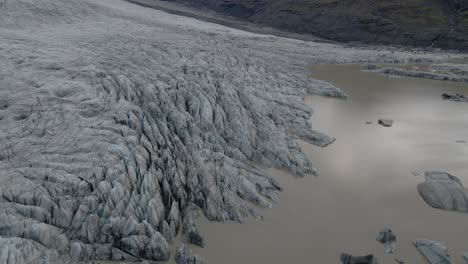 Topdown-view-of-Ice-melted-lagoon-from-Skaftafell-Glacier,-Climate-crisis,-Slowly-Tilt-up