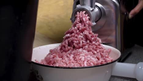 Pile-of-minced-pork-meat-with-electric-machine-on-domestic-table