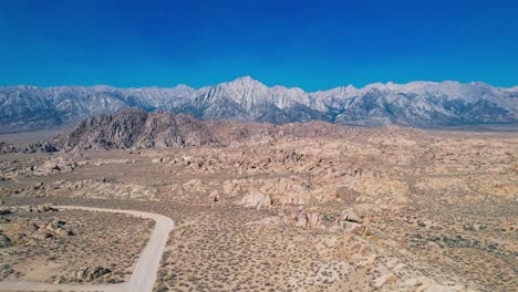 Alabama-Hills-in-Lone-Pine-California-4k-Drone-Footage-Long-Pull-Back-Shot-over-Movie-Road-with-Mount-Whitney-in-the-Background