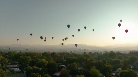 Hot-air-balloons-floating-above-an-American-town,-racing-to-their-destination