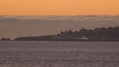 Sonnenuntergang-über-Stadt-Und-Marine-In-Cascais-Mit-Dem-Leuchtturm,-Der-Licht-Gibt,-Portugal