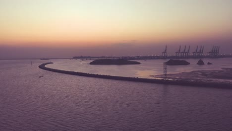 Orangefarbener-Sonnenuntergang-Am-Horizont-Mit-Dem-Hafen-Von-Karachi,-Der-Vom-Strand-Mit-Meerblick-Aus-Gesehen-Wird