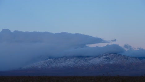 Nubes-Rodando-Sobre-Un-Pico-De-Montaña-Cubierto-De-Nieve-Al-Amanecer---Lapso-De-Tiempo