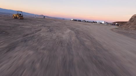 FPV-low-flight-above-arid-gravel-road-,-Mojave-Desert,-Vegas