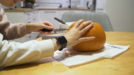 slider-shot-of-a-woman-carving-orange-pumpkin-at-home-for-the-Halloween