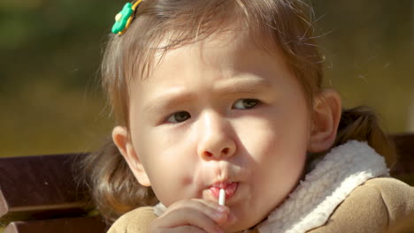 Extreme-close-up,-Korean-Ukrainian-girl-sucking-on-lollipop,-Yangjae-Park,-South-Korea