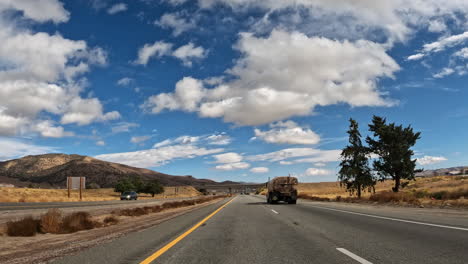 Conduciendo-Por-Una-Carretera-A-Través-Del-Desierto-De-Mojave-En-Un-Hermoso-Día--punto-De-Vista-Del-Conductor