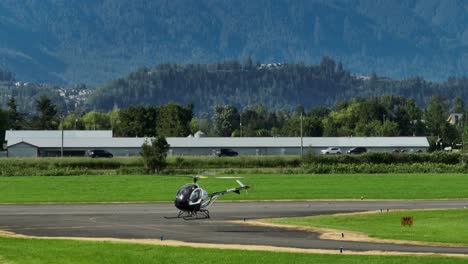 A-Helicopter-At-The-Chilliwack-Airport-In-British-Columbia,-Canada---aerial-drone-shot