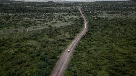 Aerial-view-of-a-white-4x4-car-traveling-in-East-Africa