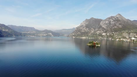 Drone-slowly-flies-from-monte-isola-to-Loreto-island-on-Iseo-lake-during-a-sunny-autumn-day