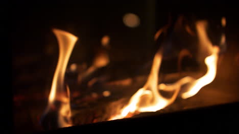 Fire-with-Smooth-flames-dancing,-rack-focus-to-defocused-bokeh-Background,-Close-Up-Slow-Motion