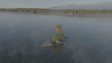 Einsame-Insel,-Umgeben-Von-Leichtem-Nebel,-Der-Eine-Luftaufnahme-Umkreist